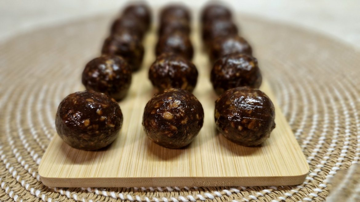 Μπάλες ενέργειας με ταχίνι και χουρμάδες πάνω σε ξύλινη επιφάνεια